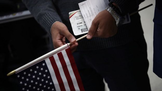 A man holds travel documents after arriving from Yemen at Dulles International airport in Washington, DC.