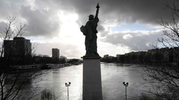 A picture taken on January 26, 2018, shows the flooded Ile aux Cygnes and banks of the River Seine with a model of the Statue of Liberty in Paris.