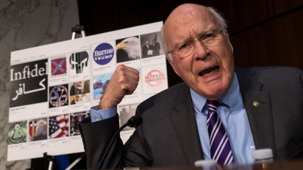 Sen. Patrick Leahy with examples of Russian-created Facebook pages behind him,