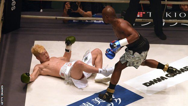 Japanese kickboxer Tenshin Nasukawa (left) is floored by former world champion boxer Floyd Mayweather (right) in an exhibition boxing match in Tokyo