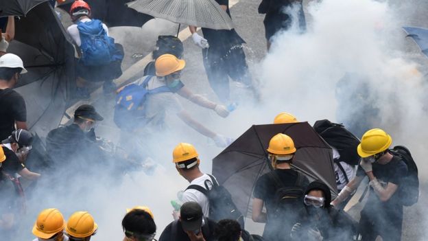 Manifestantes reaccionan al lanzamiento de gas lacrimógeno por parte de la policía en Hong Kong, junio 12, 2019