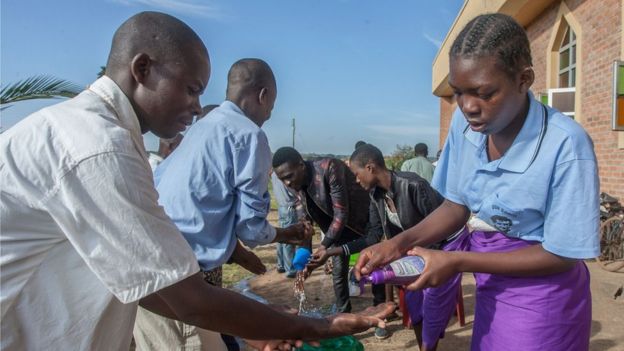 Parishioners wash hands as a preventive measure against the spred of the COVID-19 coronavirus