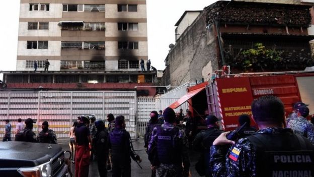 Soldados perto de um prédio com marcas de incêndio