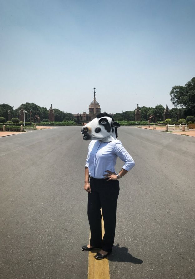 A woman with a cow mask in front of the presidential palace