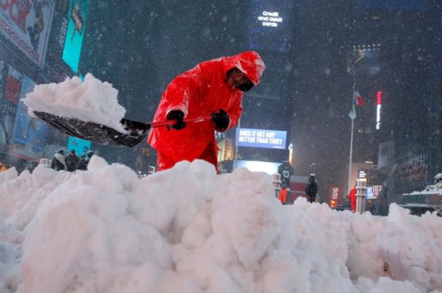 A worker clears snow in Times Square as snow falls in Manhattan, New York, U.S., on 14 March, 2017.