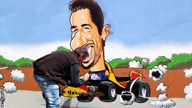 An artist paints a Daniel Ricciardo mural