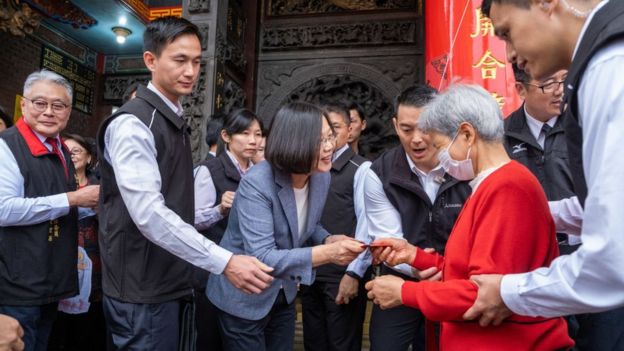 President Tsai Ing-wen distributes a red envelope to an old woman.