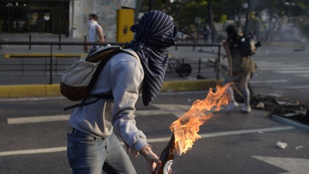 Una manifestante encapuchado