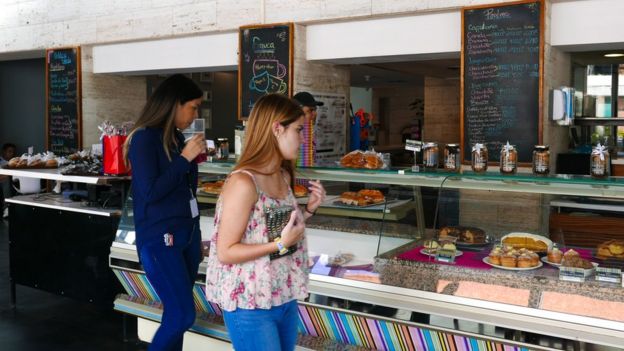 Duas clientes olham as vitrines de um café da rede Franca