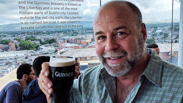 Steve Becker holding up a pint of Guinness beer