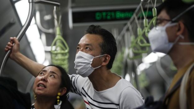 A man wearing a protective mask (C) rides the train in Singapore