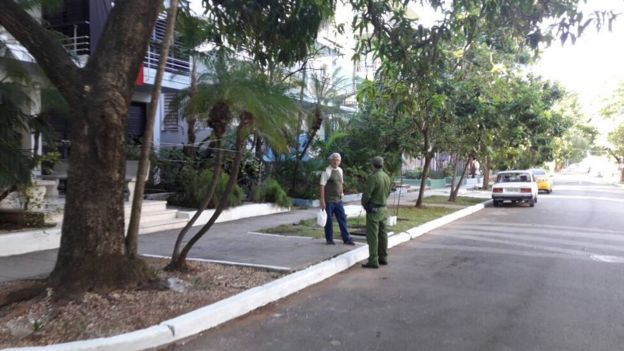 Un guardia vestido de verde en la calle.