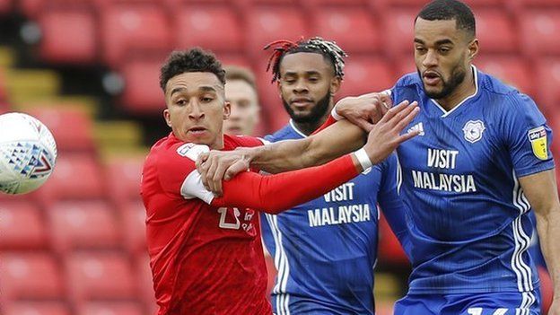 Curtis Nelson of Cardiff and Jacob Brown of Barnsley challenge for the ball