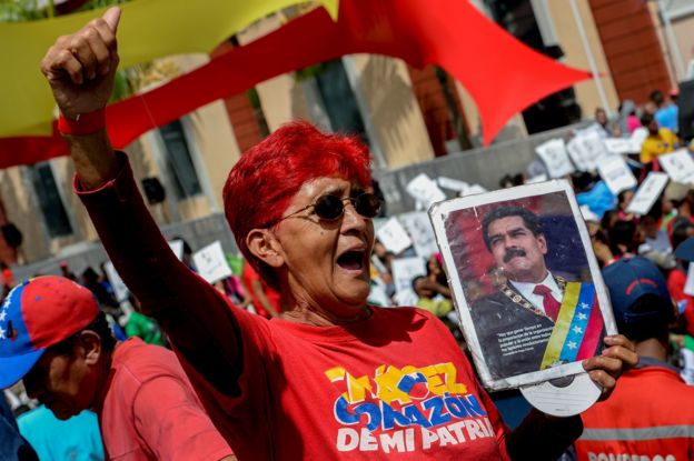 Una mujer con un retrato de Maduro