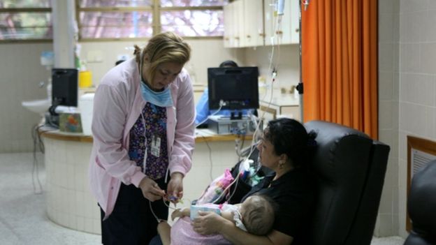 Un bebé en brazos de su madre recibe atención médica