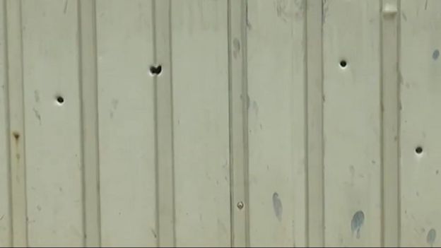 சுதேஷ் வீட்டின் மீது நடந்த துப்பாக்கிச் சூட்டில் அவரது வீட்டு கேட்டில் ஏற்பட்ட துளைகள்.