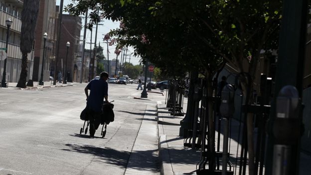 Una persona recoge materiales reciclables en un carrito en las calles de Stockton
