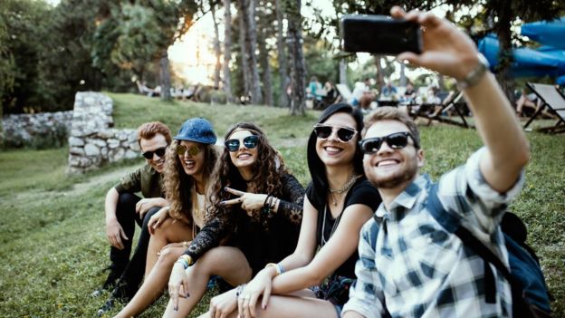 Grupo de millenials se toma una selfie.