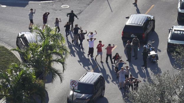 People are brought out of the Marjory Stoneman Douglas High School after a shooting at the school that reportedly killed and injured multiple people on February 14, 2018