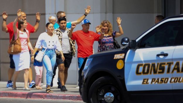 Shoppers exit with their hands up after a mass shooting at a Walmart in El Paso, Texas.