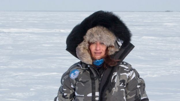 Carla Santana Torres con chaqueta y gorro para la nieve en la tundra, en medio de planicies cubiertas de hielo