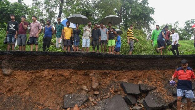 Onlookers gather at the site of a wall collapse in Mumbai on July 2, 2019