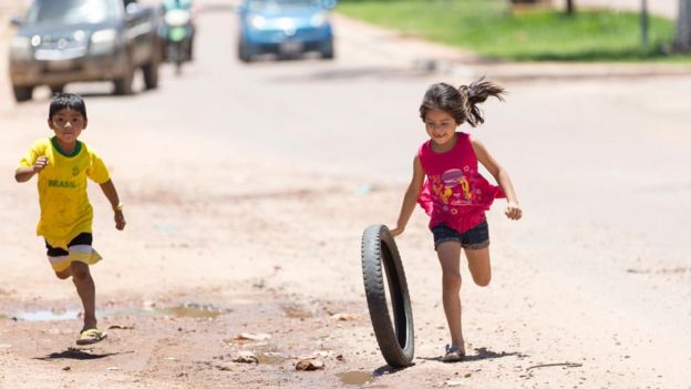 Niños corren por la calle en Guatemala.