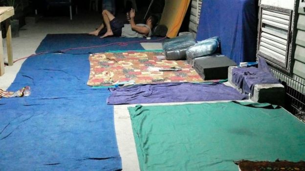 An asylum seekers lies on the ground the closed centre