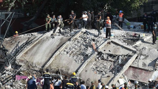 Rescuers and volunteers remove rubble and debris from a flattened building in search of survivors after a powerful quake in Mexico City on September 19, 2017.