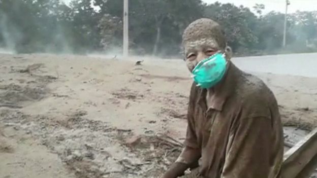 Don Concepción, totalmente cubierto por las cenizas, sentado frente a un lago de lava en el que murieron varias personas, en el municipio de Esquintla, al que pertenece la aldea de El Rodeo.