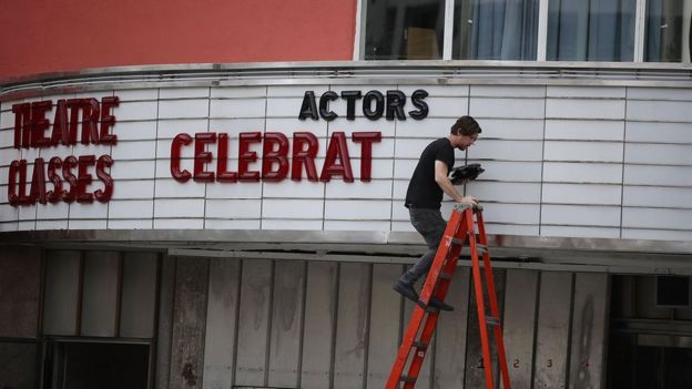 Un hombre saca las letras de la marquesina de un teatro en Coral Gables.