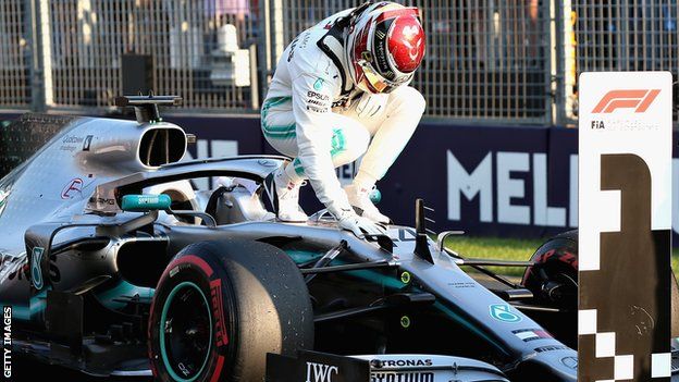 Lewis Hamilton celebrates on his car after claiming pole position in Melbourne