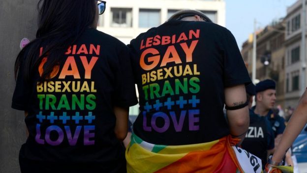 Twe people at 2019 Rome Pride wear shirt that says Lesbian Gay Bisexual Trans + love