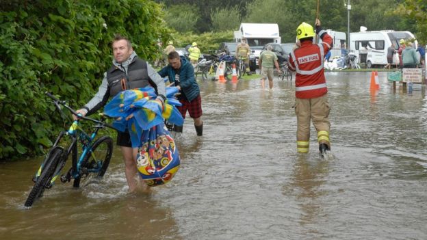 Firefighters help campers, carrying bikes from their motorhomes in Pembrokeshire