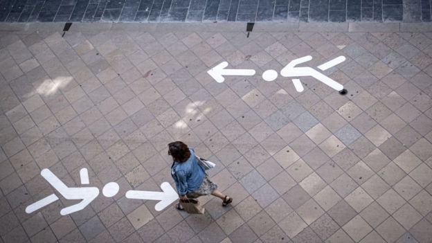 Acera señalizada en Burdeos, Francia, y una mujer caminando en contravía.