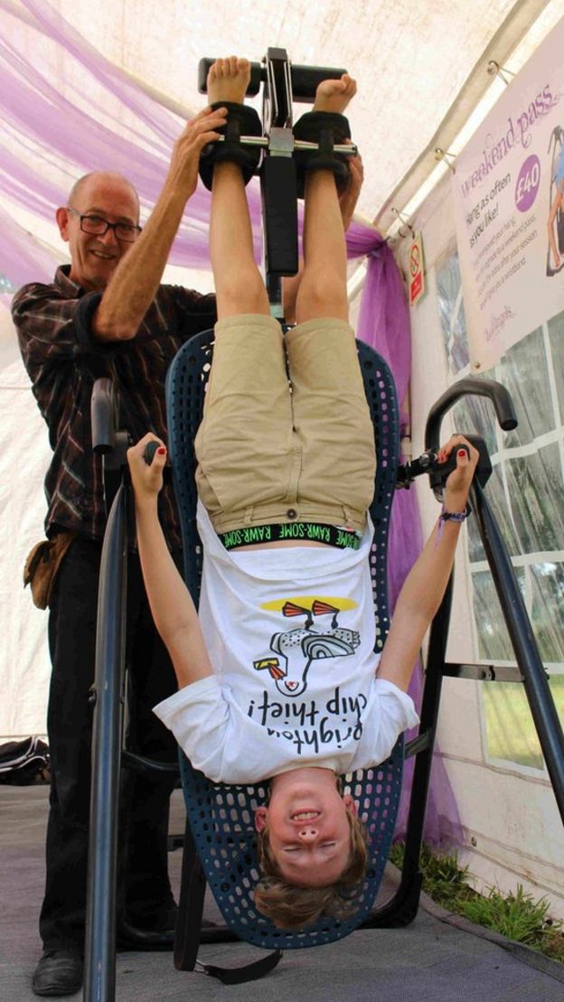 A young festival-goer undergoes inversion therapy