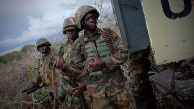 Soldiers serving with the African Union Mission in Somalia walk in front of an armoured personnel carrier on May 22, 2012