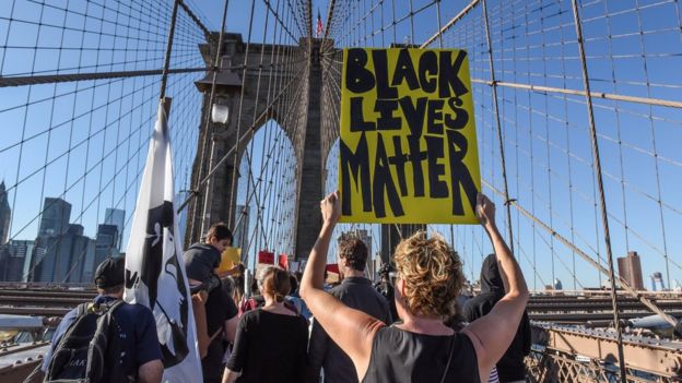 Manifestante com cartaz do Black Lives Matter em passeata em Nova York