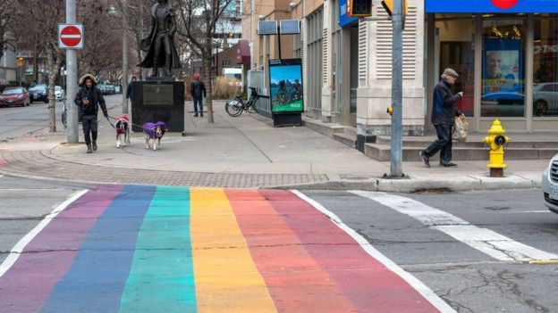 A city crosswalk painted in the rainbow colours of the LGBT flag in downtown Toronto
