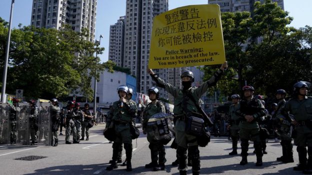 香港新界屯门防暴警察向示威群众展示警告旗号(21/9/2019)