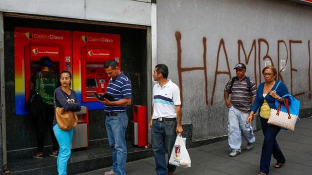 Gente al lado de un cajero en Venezuela.