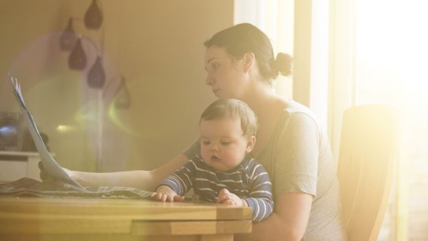 Mulher com bebê no computador