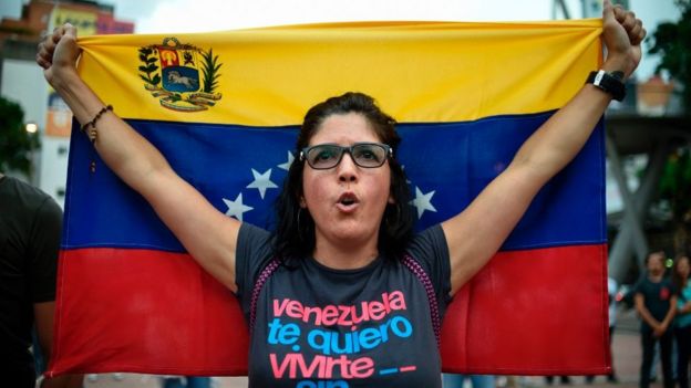 Una mujer con una bandera de Venezuela.