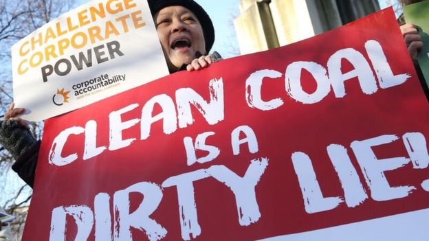 A protester holds up signs