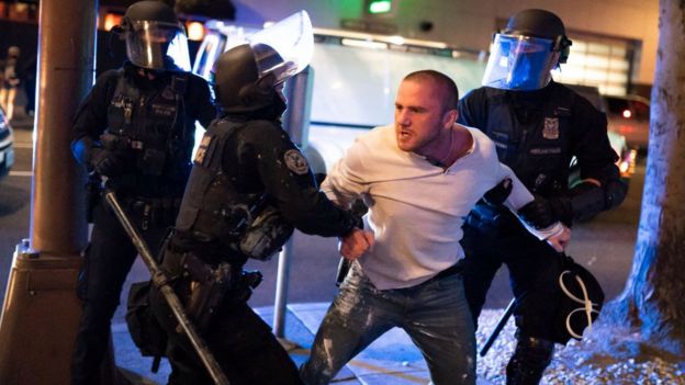 Police restraining a man during the Portland clashes