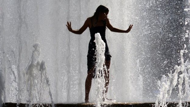A girl stands in a fountain in downtown Prague as a heatwave hits the Czech Republic, 1 August 2017
