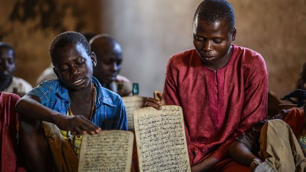 Kids from different district of Nigeria learn to read and memorize the verses of the Quran written with ink on wooden panels at a boarding school in Jimeta, Nigeria on December 08, 2014