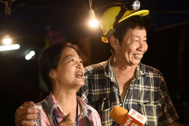 Family members celebrate while camping out near Than Luang cave following news all members of children's football team and their coach were alive in the cave at Khun Nam Nang, 2 July