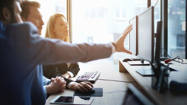 Tres personas frente a un computador