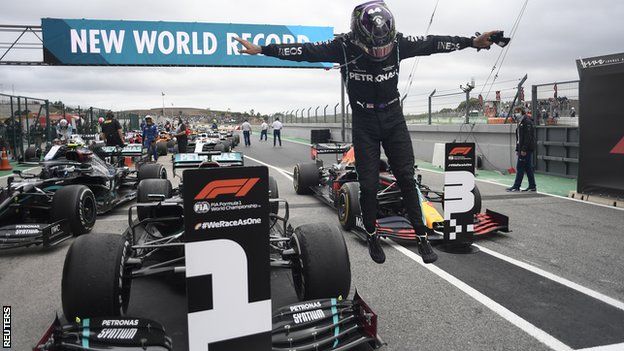 Lewis Hamilton jumps off his car after winning the Portuguese Grand Prix